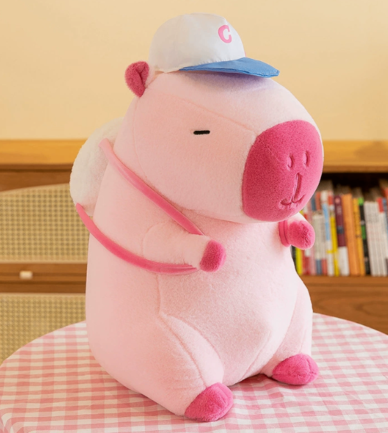 Pink CapyCuddle capybara plush with blue cap and backpack