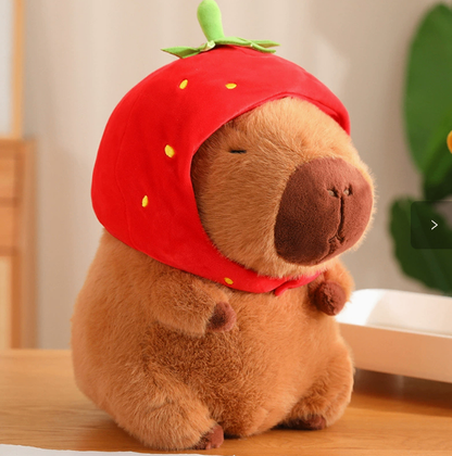 CapyCuddle capybara plush wearing a red strawberry hat